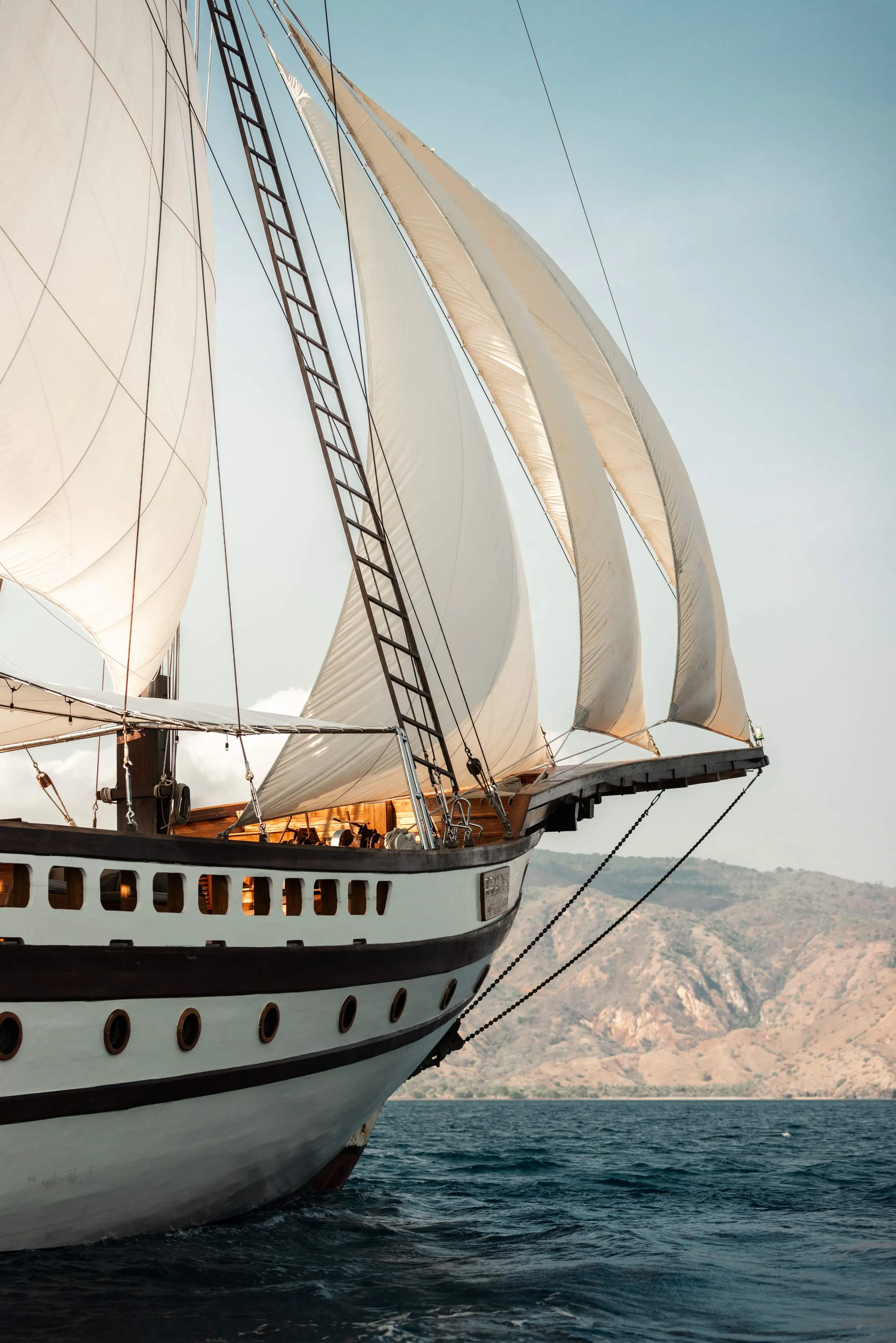 Prana under full sail, her bow and hull from the waterline